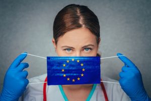 Coronavirus in European Union, Female Doctor Portrait hold protect Face surgical medical mask with Europa Union Flag. Illness, Virus Covid-19 in EU, concept photo