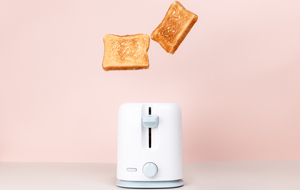 Toasts jumping out of white toaster.