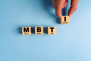 Wooden blocks with the letters MBTI on blue background. Personality typology. Psychology test for human types.MBTI – Myers-Briggs Type Indicator.
