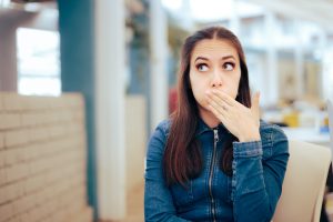 Woman Sitting in a Restaurant Feeling Sick and Nauseated