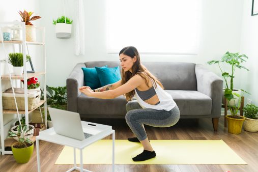 Side view of a good-looking woman exercising at home