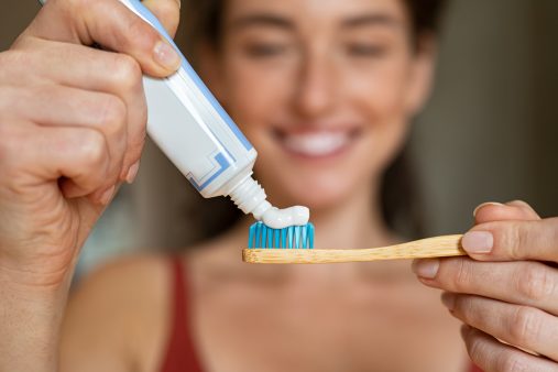 Mujer aplicando pasta de dientes en un cepillo