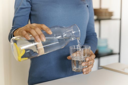 Mujer vertiendo agua en un vaso