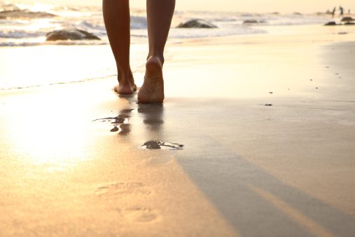 Imagen de pies caminando por la arena