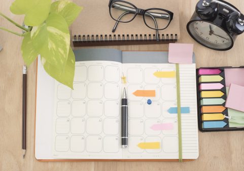 Organización del tiempo: hábitos para mejorar productividad y bienestar Agenda con calendario, post-its y bolígrafo