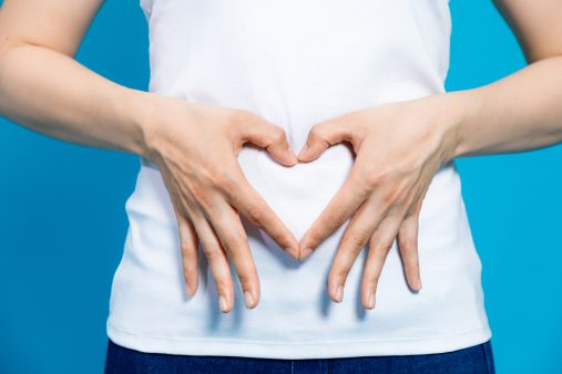 Mujer mayor dibujando en la tripa un corazón